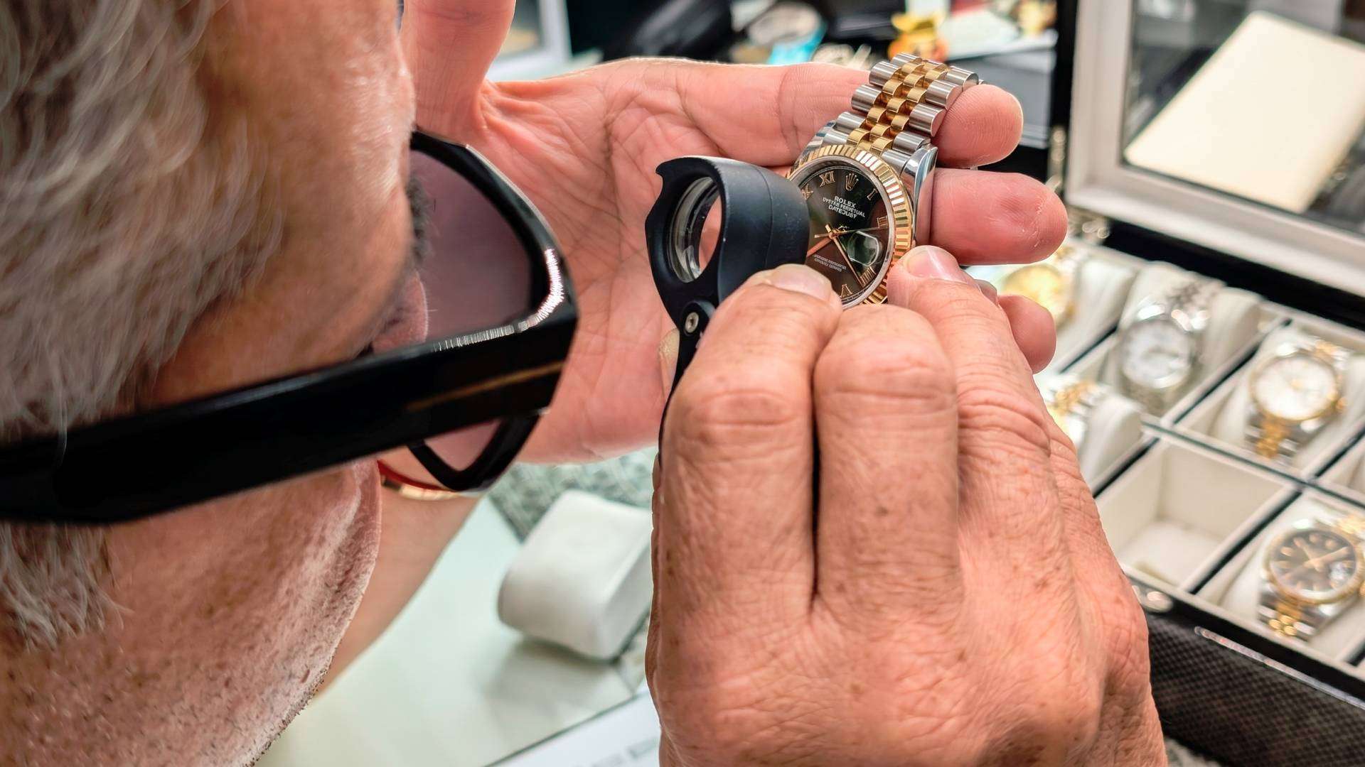 Cómo Identificar un Rolex Original y Evitar Falsificaciones 1 Relojero experto de Luxury Grimal inspeccionando el calibre y el movimiento mecánico de un reloj de lujo para verificar su autenticidad