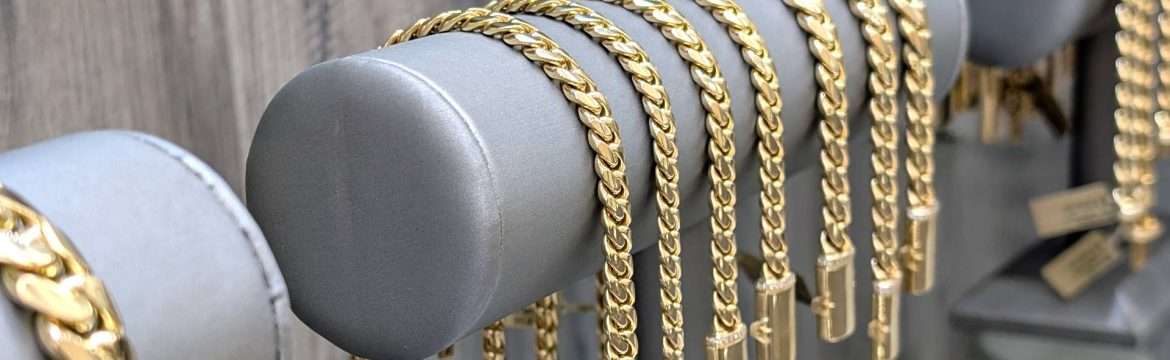 Gold chains displayed on a rack.